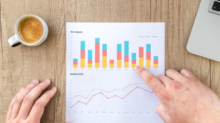 Decorative image of a piece of paper on a table with graphs