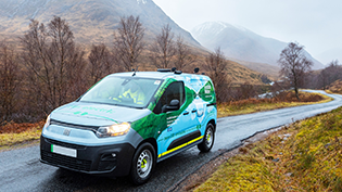 Scottish Water van on the road through Glencoe with snowy mountain backdrop