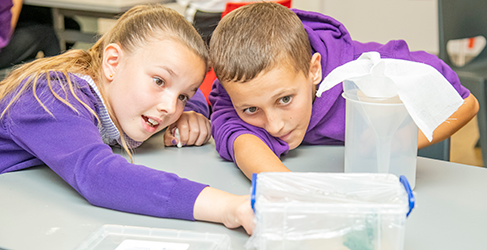 A young girl and boy from St Pius Primary School in Dundee busy with a water experiment at Scottish Water Generation H2O Water cycle workshop 