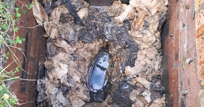 A drain blocked with rags and wipes
