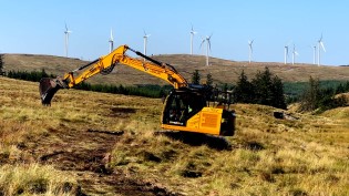 A digger at work on a peatland restoration site at Afton Reservoir, East Ayrshire