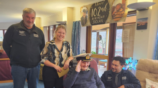 Dolan MacAskill marks his 102nd birthday with members of the project team
