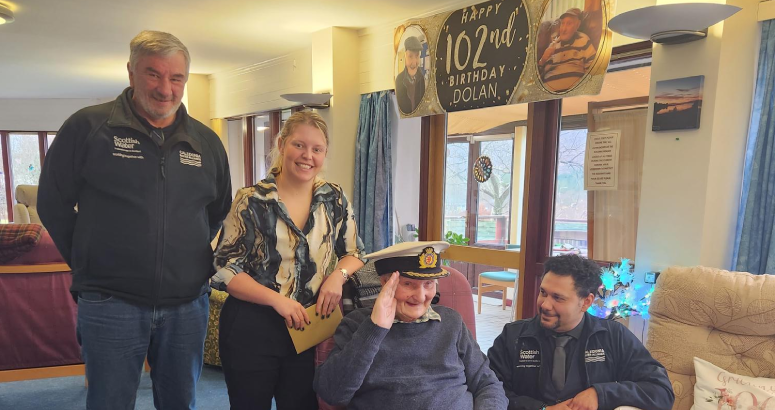 Dolan MacAskill marks his 102nd birthday with members of the project team