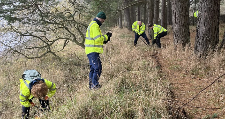 Volunteers cutting wire along the reservoir